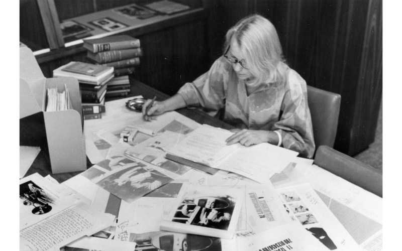 A portrait of Joan Warnow-Blewett looking over many records. She served as an archivist at the Niels Bohr Library & Archives and Associate Director for the Center for History of Physics at the American Institute of Physics.