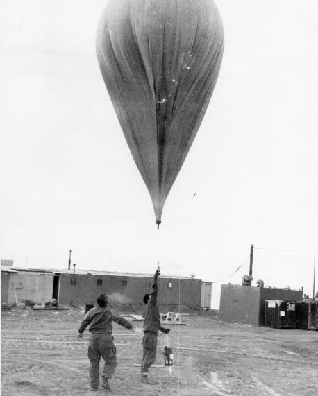 John A. Brown helps Emmett J. Pybus as they release a balloon on a calm day in the Antarctic