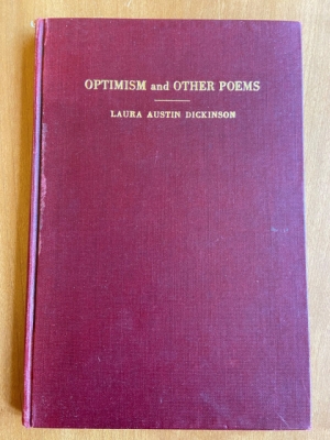 a slim book, maybe a centimeter deep, with a red cover and embossed gold lettering reading "Optimism and Other Poems" and "Laura Dickinson" 