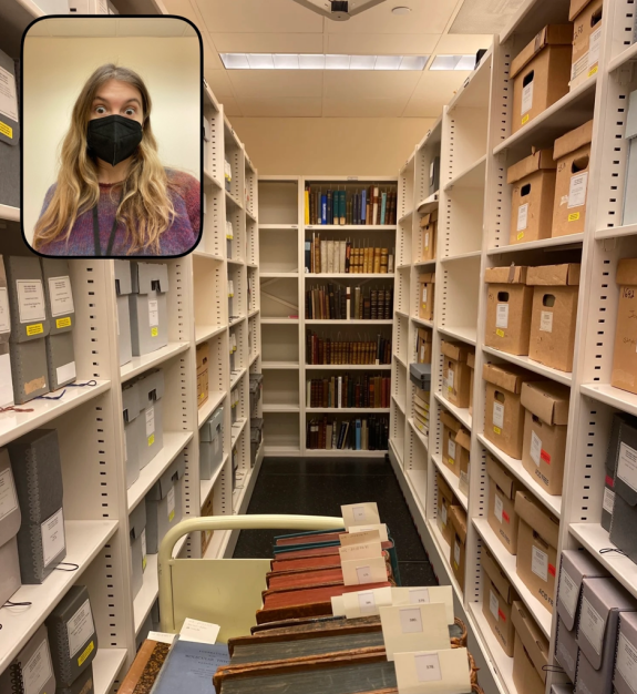 BeReal screenshot with selfie in the top left corner, and main image of looking down an archival stacks, with two shelves on each side an a third ahead. The shelves are stacked with books and a book cart is visible in the forefront.