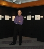 Professor Richard Zallen at the center of the photo in front of a 'art show' of physics-as-art at Wallace Hall, Virginia Tech, with seven images posted on a dark background