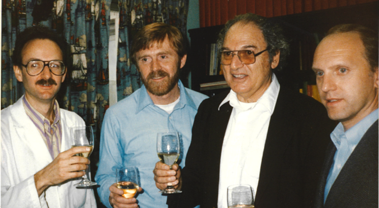 Image of four men holding champagne glasses.
