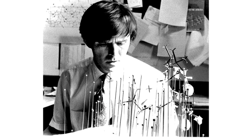 Black and white photo of man looking at scientific model