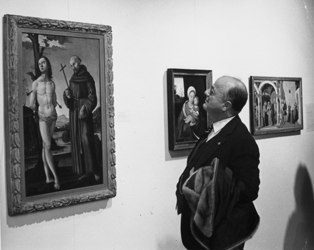 Clifford Truesdell stands in front of three Renaissance paintings