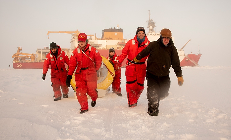 Crew from the U.S. Coast Guard Cutter Healy pull a buoy across Arctic sea ice in 2018.