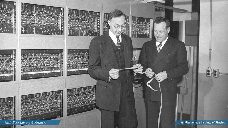 Professor Abraham H. Taub and Professor Ralph E. Meagher examine an ILLIAC I tape. 