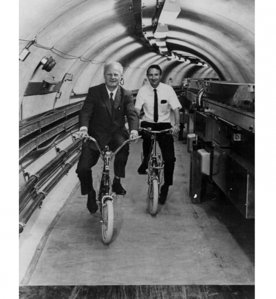 Hans Bethe and Boyce McDaniel ride bicycles in the Cornell Electron Storage Ring 