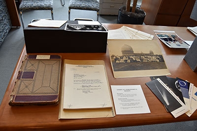 Close-up of American Astronomical Society (AAS) portion of exhibit with handwritten meeting notebook, “crank mail” file, pamphlets, and photograph of 1922 annual meeting at Yerkes Observatory.